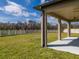 A covered patio overlooks a spacious backyard enclosed by a white fence, perfect for outdoor enjoyment at 3150 Marine Grass Dr, Wimauma, FL 33598