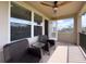 Relax on this covered balcony featuring outdoor chairs and a table, and a ceiling fan for comfort at 3150 Marine Grass Dr, Wimauma, FL 33598