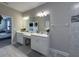 Bathroom featuring double vanity, white cabinets, large mirror, and tiled floors and backsplash at 3150 Marine Grass Dr, Wimauma, FL 33598