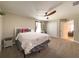 Bedroom with a wood-blade ceiling fan and neutral tones, with view of the ensuite bathroom at 3150 Marine Grass Dr, Wimauma, FL 33598