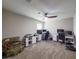 Bedroom featuring neutral walls and carpet, two desks with computers, and a ceiling fan at 3150 Marine Grass Dr, Wimauma, FL 33598