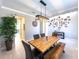 Dining room featuring a wooden table with bench, stylish lighting, and neutral wall decor at 3150 Marine Grass Dr, Wimauma, FL 33598