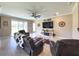 Cozy living room featuring recliners, a ceiling fan, and a decorative fireplace with a mounted television at 3150 Marine Grass Dr, Wimauma, FL 33598