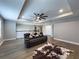 Upstairs living room with tray ceilings, ceiling fan, wood floors, and neutral decor at 3150 Marine Grass Dr, Wimauma, FL 33598