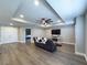 Spacious second-floor living room featuring a large couch, wood floors, and tray ceilings at 3150 Marine Grass Dr, Wimauma, FL 33598