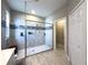 Bathroom shower with light gray tiles, mosaic backsplash, glass enclosure and built in bench at 3150 Marine Grass Dr, Wimauma, FL 33598