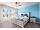 Serene main bedroom with blue accent wall, ceiling fan, and bright windows at 33846 Floating Heart Ct, Wesley Chapel, FL 33545