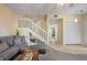 Bright living room featuring a staircase, neutral paint, and gray carpet at 3460 Countryside Blvd # 19, Clearwater, FL 33761