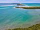 Breathtaking aerial view of a pristine waterfront with turquoise waters and sandy beaches at 3667 Arbor Chase Dr, Palm Harbor, FL 34683