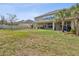 Expansive backyard featuring a covered patio, ample green space, and privacy fencing at 3667 Arbor Chase Dr, Palm Harbor, FL 34683