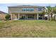 Expansive backyard with lush lawn, covered patio seating, and mature landscaping for outdoor enjoyment at 3667 Arbor Chase Dr, Palm Harbor, FL 34683