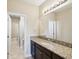 Bathroom features a granite countertop with dark wood cabinets and a large framed mirror at 3667 Arbor Chase Dr, Palm Harbor, FL 34683