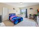 Bright bedroom with a colorful bedspread, a crib, and a window overlooking the outdoors at 3667 Arbor Chase Dr, Palm Harbor, FL 34683