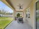 Relaxing covered patio with an outdoor dining set and a view of the landscaped backyard at 3667 Arbor Chase Dr, Palm Harbor, FL 34683