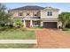 Beautiful two-story home featuring a brick driveway and well-maintained lawn at 3667 Arbor Chase Dr, Palm Harbor, FL 34683