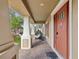 Welcoming front porch with a swing chair, brick flooring, and a stylish front door at 3667 Arbor Chase Dr, Palm Harbor, FL 34683