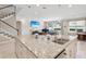 Open kitchen featuring a granite island and bar with pendant lighting, seamlessly flowing into the living space at 3667 Arbor Chase Dr, Palm Harbor, FL 34683