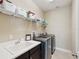 Bright laundry room with stainless steel washer and dryer, plus overhead storage shelving at 3667 Arbor Chase Dr, Palm Harbor, FL 34683