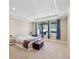 Spacious main bedroom with tray ceiling, large windows, and a decorative upholstered storage bench at 3667 Arbor Chase Dr, Palm Harbor, FL 34683