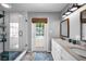 Modern bathroom features a glass-enclosed shower, double sinks, and an exterior door leading to the pool area at 3727 38Th N St, St Petersburg, FL 33713