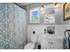 Cozy bathroom with a patterned shower curtain, white fixtures, and natural light from the window at 3727 38Th N St, St Petersburg, FL 33713