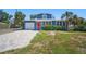 Charming home with a red door, a well-kept lawn, and a paved driveway leading to the garage at 3727 38Th N St, St Petersburg, FL 33713
