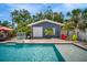 Pool area with an additional building with double doors, lounge chairs, and lush landscaping at 3727 38Th N St, St Petersburg, FL 33713