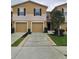 Inviting townhouse featuring a well-maintained lawn, two-car garage, and neutral exterior color scheme at 4224 Winding River Way, Land O Lakes, FL 34639