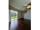 Bright living room featuring hardwood floors, a ceiling fan, and sliding glass doors with a backyard view at 4224 Winding River Way, Land O Lakes, FL 34639