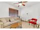 Living room with tile floors, ceiling fan, sofa, window with blinds, and a red chair at 4418 Carlyle Rd, Tampa, FL 33615