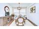 Formal dining room with elegant chandelier, neutral-toned rug, and a large sideboard cabinet at 4627 Tramanto Ln, Wesley Chapel, FL 33543