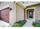 Inviting front entrance with a decorative front door, stone accents, and manicured shrubbery at 4627 Tramanto Ln, Wesley Chapel, FL 33543