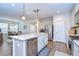 Beautiful open kitchen featuring an island with stainless steel dishwasher, pendant lights, and wood-look tile flooring at 4627 Tramanto Ln, Wesley Chapel, FL 33543