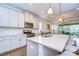 Bright kitchen features white cabinets, stainless steel appliances, and a large center island with pendant lighting at 4627 Tramanto Ln, Wesley Chapel, FL 33543