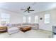 Spacious living room featuring a large sectional couch, ceiling fan, and natural lighting at 4627 Tramanto Ln, Wesley Chapel, FL 33543