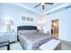Comfortable main bedroom featuring decorative lamps on the nightstands, and an en-suite bathroom at 4627 Tramanto Ln, Wesley Chapel, FL 33543