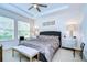 Main bedroom with tray ceiling, decorative lamps, and a bench at the end of the comfortable looking bed at 4627 Tramanto Ln, Wesley Chapel, FL 33543
