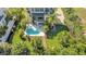 Aerial view of backyard oasis features a pool, lush landscaping, a covered patio, and a spiral staircase at 4707 Troydale Rd, Tampa, FL 33615