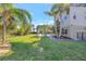 Beautifully landscaped backyard with lush lawn, palm trees, and a view of the pool at 4707 Troydale Rd, Tampa, FL 33615