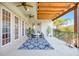 Cozy covered balcony featuring a ceiling fan, outdoor dining set, and scenic surroundings at 4707 Troydale Rd, Tampa, FL 33615