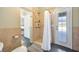 Cozy full bathroom showcasing a tiled shower with curtain and a view to the Main bedroom at 4707 Troydale Rd, Tampa, FL 33615
