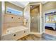 Bright bathroom featuring tiled tub surround, walk-in shower, and private water closet at 4707 Troydale Rd, Tampa, FL 33615