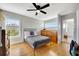 Bedroom with hardwood floors, a ceiling fan, a bed, and a view from the window at 4707 Troydale Rd, Tampa, FL 33615