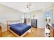 Comfortable bedroom with hardwood floors, a ceiling fan, a desk, and plenty of natural light at 4707 Troydale Rd, Tampa, FL 33615
