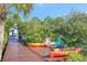 Colorful chairs and kayaks on a private wooden dock surrounded by lush vegetation at 4707 Troydale Rd, Tampa, FL 33615
