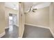 Hallway with freshly painted walls and trim, and gray floors that lead to multiple rooms with overhead lighting at 4707 Troydale Rd, Tampa, FL 33615