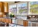 Close up on kitchen stainless steel sink, faucet, backsplash, and a window with outdoor view at 4707 Troydale Rd, Tampa, FL 33615