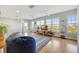 Bright living room with hardwood floors, large windows with blinds, ceiling fans, and beanbag chairs at 4707 Troydale Rd, Tampa, FL 33615