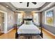 Stylish main bedroom featuring a tray ceiling, hardwood floors, and plenty of natural light at 4707 Troydale Rd, Tampa, FL 33615
