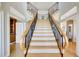 Beautiful staircase with wood treads and decorative railings, bathed in natural light, creates a grand entrance at 4707 Troydale Rd, Tampa, FL 33615